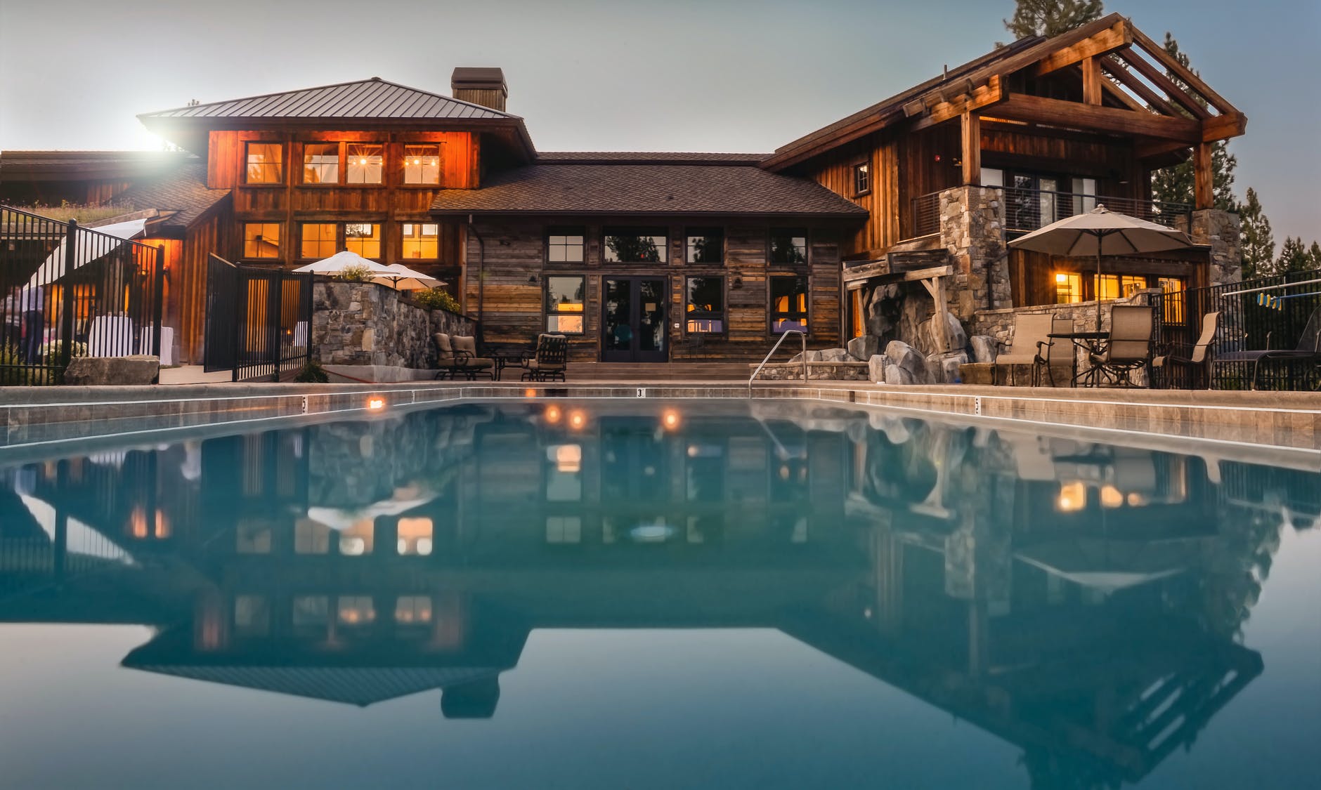 brown wooden house infront of swimming pool under blue sky